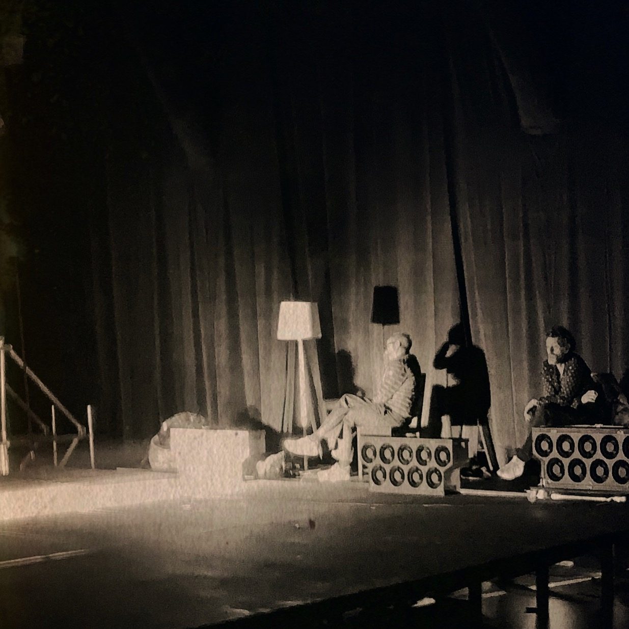 Comédiens assis parmi les lampadaires et les caissons lumineux, scénographie de Prométhée Enchaîné par L'Illustre Atelier